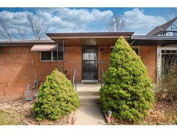 Charming brick home featuring well-maintained landscaping and a secure front entry at 5132 Eaton St, Denver, CO 80212