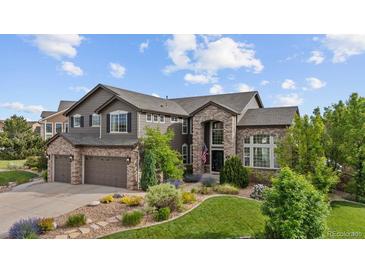 Beautiful two-story home with stone and siding, complemented by a well-manicured lawn and landscaping at 7408 Sodalite Way, Castle Rock, CO 80108
