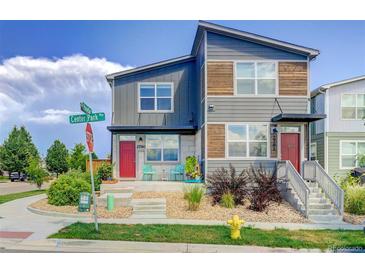 Modern townhome with gray siding, wood accents, and a welcoming red front door at 2790 Center Park Way, Berthoud, CO 80513