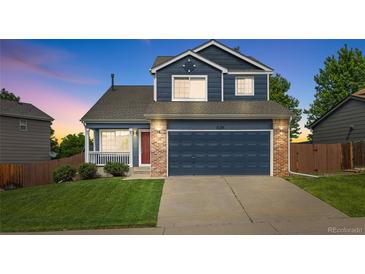 Charming two-story home featuring a blue exterior, brick accents, and a well-maintained front yard at 5124 S Jebel St, Centennial, CO 80015