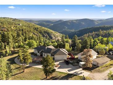 Stunning mountain home with a circular driveway and views of the surrounding green landscape at 12291 S Critchell Ln, Littleton, CO 80127