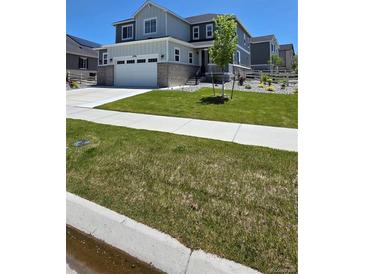 Charming two-story home with a two-car garage and a well-manicured lawn on a sunny day at 27986 E Frost Pl, Aurora, CO 80016