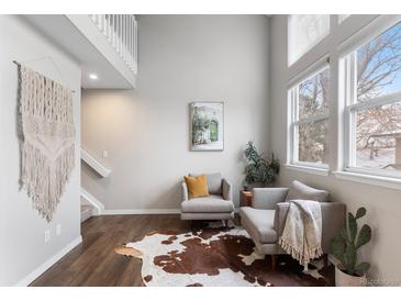 Bright living room with vaulted ceilings, large windows, hardwood floors, and modern furnishings at 6450 W 44Th Pl # B-3, Wheat Ridge, CO 80033