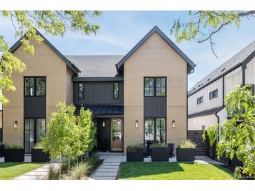 Charming two-story home featuring a brick exterior, black trim, and a well-manicured front yard at 3934 Kalamath St, Denver, CO 80211