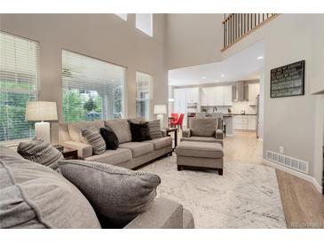 Bright living room with soaring ceilings, neutral paint, large windows and view of the kitchen at 24686 E Florida Ave, Aurora, CO 80018