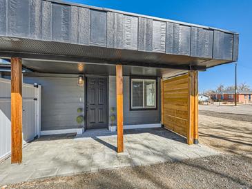 Welcoming front entrance featuring a stylish door, decorative plants, and a modern, covered porch area at 5951 Oneida St, Commerce City, CO 80022