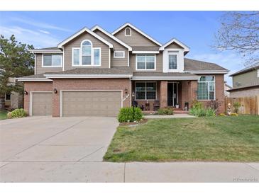 Charming two-story home with a well-manicured lawn and attached two car garage at 11615 E Maplewood Ave, Englewood, CO 80111