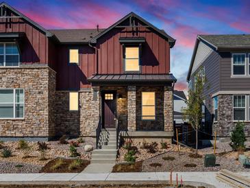 Two-story home with stone and red siding, front porch, and landscaping at 8115 Mt Harvard Rd, Littleton, CO 80125