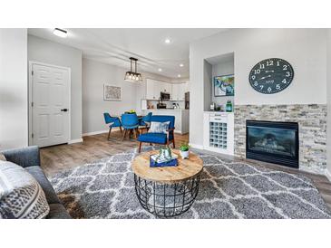 Bright living room featuring a fireplace with stone accents, hardwood floors, and stylish furnishings at 5555 E Briarwood Ave # 2604, Centennial, CO 80122
