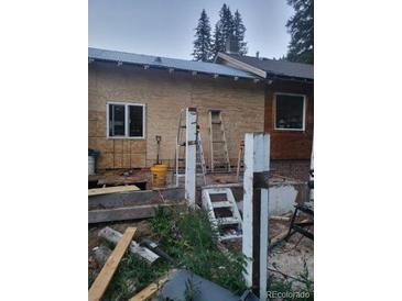 Exterior view of a home under construction with ladders and building materials around the property at 4568 Apex Valley Rd, Golden, CO 80403