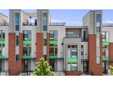 Contemporary townhouse featuring a red brick facade, sleek gray accents, and a rooftop terrace at 3008 Blake St, Denver, CO 80205