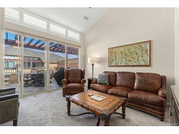 Cozy living room featuring plush seating, natural light, and access to an outdoor patio at 8643 Gold Peak Dr # E, Highlands Ranch, CO 80130