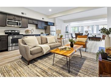 A spacious open-concept living room features stainless steel appliances and modern decor at 2901 N Wyandot St # 19, Denver, CO 80211
