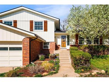 Charming home with brick accents, wood shutters, and a beautifully landscaped front yard at 6385 S Jay Way, Littleton, CO 80123
