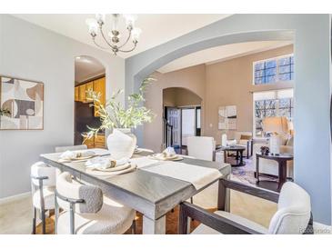 Bright dining room features an elegant chandelier, table setting and plenty of room to entertain guests at 10935 Acadia, Parker, CO 80138