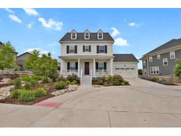 Charming two-story home with a welcoming front porch and well-manicured landscaping at 9353 Middle Fork St, Littleton, CO 80125