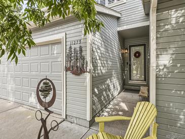 Inviting front entrance featuring a decorative wreath and a vibrant yellow adirondack chair at 11275 Holly St, Thornton, CO 80233