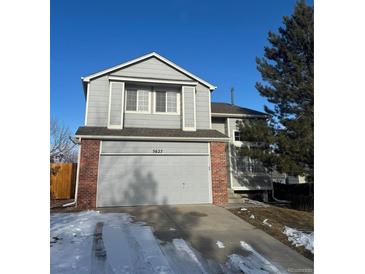 Two-story house with gray siding, brick accents, and a two-car garage at 5627 S Winnipeg St, Aurora, CO 80015