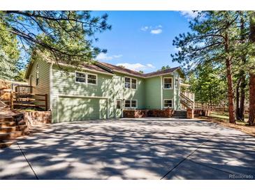 Charming two-story home with a spacious driveway and a lush green lawn, complemented by a two-car garage at 4185 Red Rock Dr, Larkspur, CO 80118