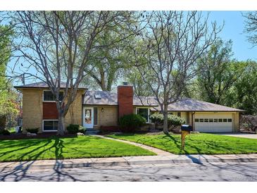 Charming brick home with a well-maintained lawn and mature trees creating an inviting curb appeal at 2330 Yarrow St, Lakewood, CO 80214
