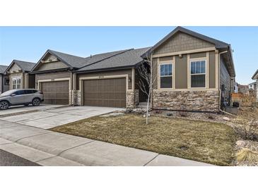 Charming home featuring a two-car garage, stone accents, and well-maintained landscaping at 6712 Sea Oats Dr, Parker, CO 80138