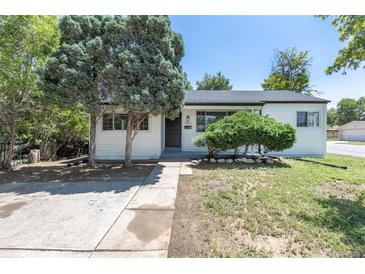 Charming single-story home with white siding, complemented by mature trees and a well-maintained lawn at 1900 Kingston St, Aurora, CO 80010