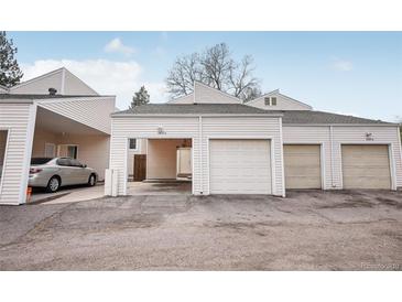 View of garages and carport with neutral siding and asphalt driveway at 1529 S Sable Blvd # C, Aurora, CO 80012