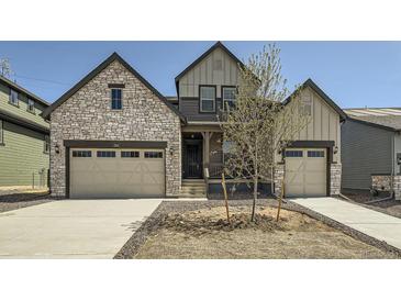 Inviting home featuring a stone facade, tandem three-car garage, and contemporary architectural details at 2924 S Poppy St, Morrison, CO 80465