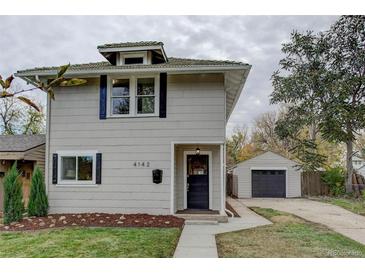 Charming two-story home featuring a detached garage and well-maintained front yard and black shutters at 4142 Chase St, Denver, CO 80212