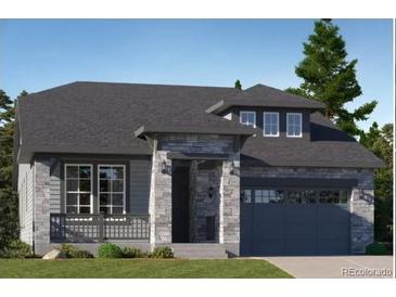 Charming single-story home with a stone facade, covered porch, and a two-car garage, exuding curb appeal at 576 Nightsky St, Erie, CO 80516