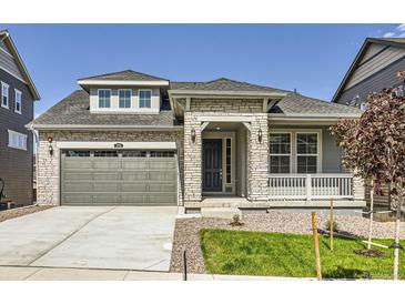 Charming exterior view of a stone-accented two-story home with a well-manicured lawn and neutral colors at 576 Nightsky St, Erie, CO 80516