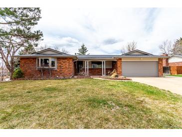 Charming one-story brick home with a well-manicured lawn and an attached two-car garage at 699 S Oswego St, Aurora, CO 80012