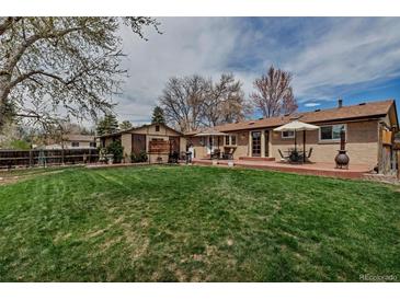 Sprawling backyard with mature trees, brick patio, grill, and detached covered outdoor dining area at 3630 W Saratoga Ave, Littleton, CO 80123