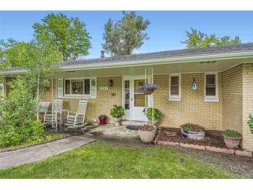 Charming brick ranch home with a cozy front porch and well-manicured landscaping at 6940 W 63Rd Ave, Arvada, CO 80003