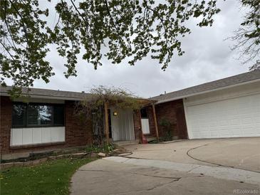 Charming one-story brick home with a two-car garage and a lush, green yard at 8895 E Radcliff E Ave, Denver, CO 80237
