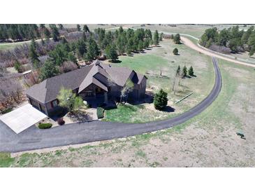 An aerial view showcases this beautiful single-Gathering home and its well-manicured lot and long driveway at 12984 Crowfoot Springs Rd, Larkspur, CO 80118