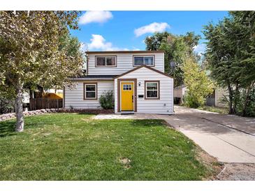 Charming home with a well-manicured lawn and a bright yellow front door at 5570 Otis Ct, Arvada, CO 80002