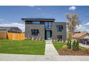 Contemporary two-story home showcasing a manicured lawn and sleek architectural design with a gray facade at 1459 W 42Nd Ave, Denver, CO 80211