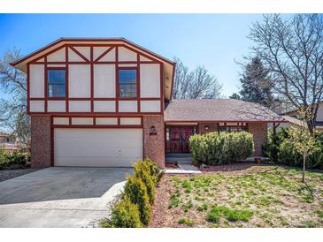 Charming two-story Tudor-style home with a brick facade and a well-manicured front yard in a suburban neighborhood at 5138 S Sedalia Ct, Centennial, CO 80015