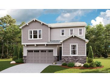 Charming two-story home with gray siding, stone accents, a two-car garage, and well-manicured landscaping at 1442 Lumber Ridge S Cir, Erie, CO 80516