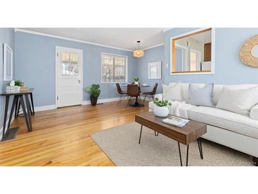 Cozy living room featuring hardwood floors, a dining area, and comfortable seating at 1755 Quince St, Denver, CO 80220