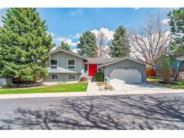 Charming two-story home with blue paint, bright red front door, and well-manicured lawn at 3722 S Quebec St, Denver, CO 80237
