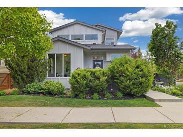 Charming two-story home with mature landscaping, manicured lawn, and inviting curb appeal at 1882 W 67Th Ave, Denver, CO 80221