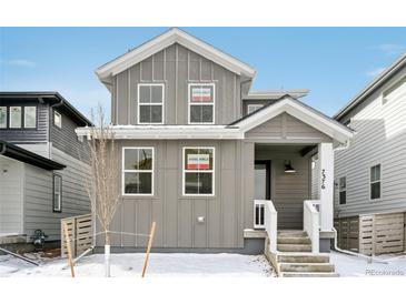 Charming two-story home with gray siding, white trim, and inviting front porch at 7376 Watercress Dr, Littleton, CO 80125