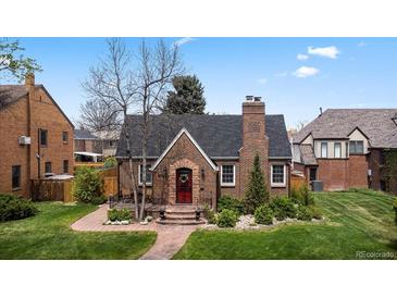 Charming brick home with a red front door, chimney, and well-maintained landscaping at 6023 E 6Th Avenue Pkwy, Denver, CO 80220