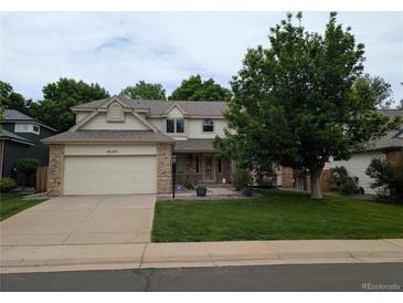 Charming two-story home featuring a two-car garage, well-manicured lawn, and mature trees providing shade at 19149 E Ida Dr, Aurora, CO 80015