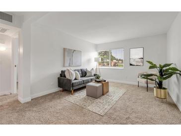 Bright living room featuring modern decor, neutral color palette, and comfortable seating arrangement at 3613 S Sheridan Blvd # 11, Denver, CO 80235