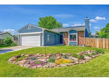 Charming single Gathering home featuring a well-manicured lawn and attractive landscaping at 9446 W Wagon Trail Cir, Littleton, CO 80123