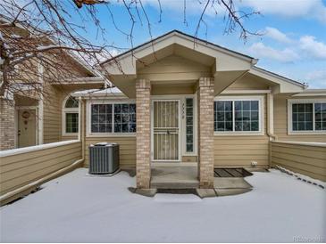 Tan exterior of house with snow covered front yard and entryway at 7770 W 90Th Dr, Broomfield, CO 80021