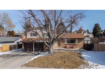 Charming two-story home with a mature tree, brick accents, two car garage, and a cozy front porch at 9430 Perry St, Westminster, CO 80031